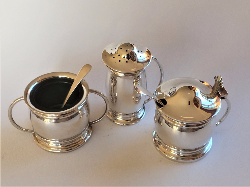 A stylish silver cruet with green liners and spoons View II