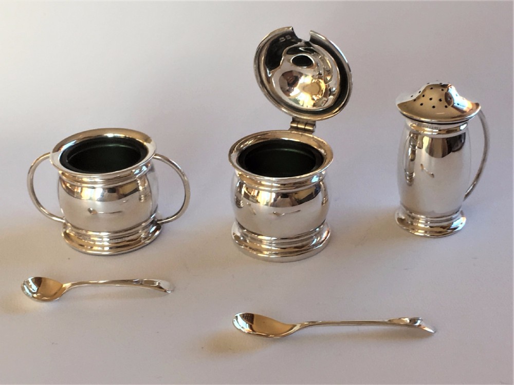 A stylish silver cruet with green liners and spoons View VI