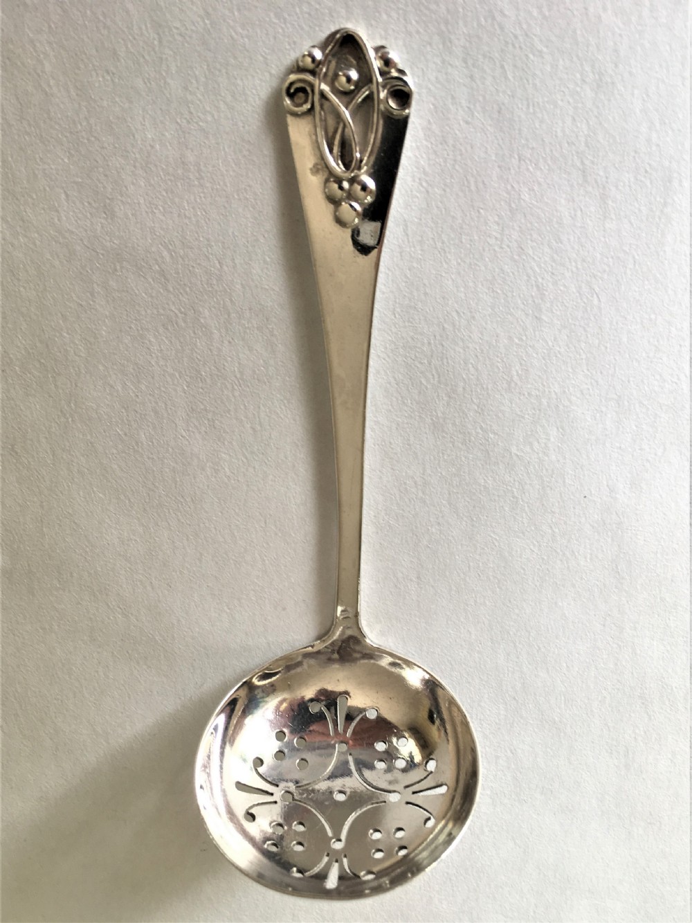 A Northwich Arts & Crafts silver sifter spoon