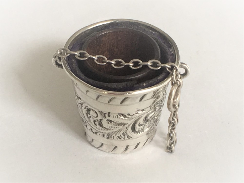 An Edwardian silver thimble bucket and treen thimble