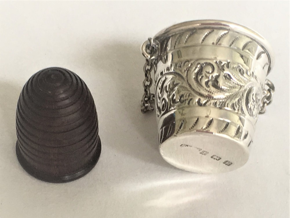 An Edwardian silver thimble bucket and treen thimble View II