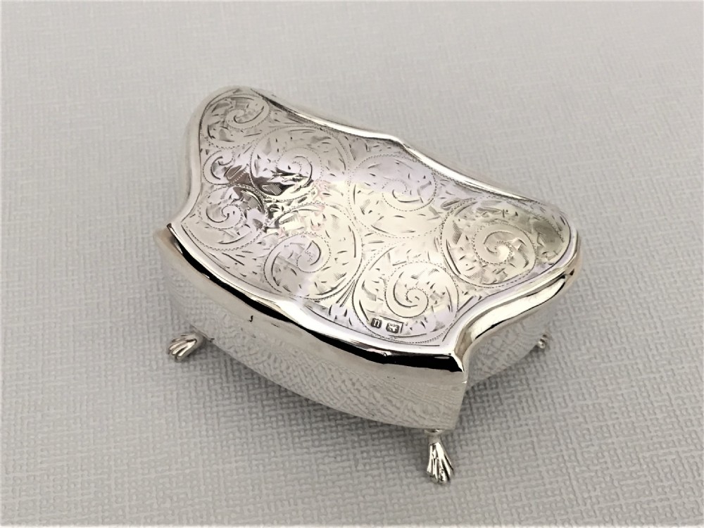 A shaped silver trinket box with engraved decoration View II