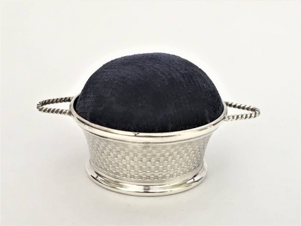 A novelty silver basket pin cushion