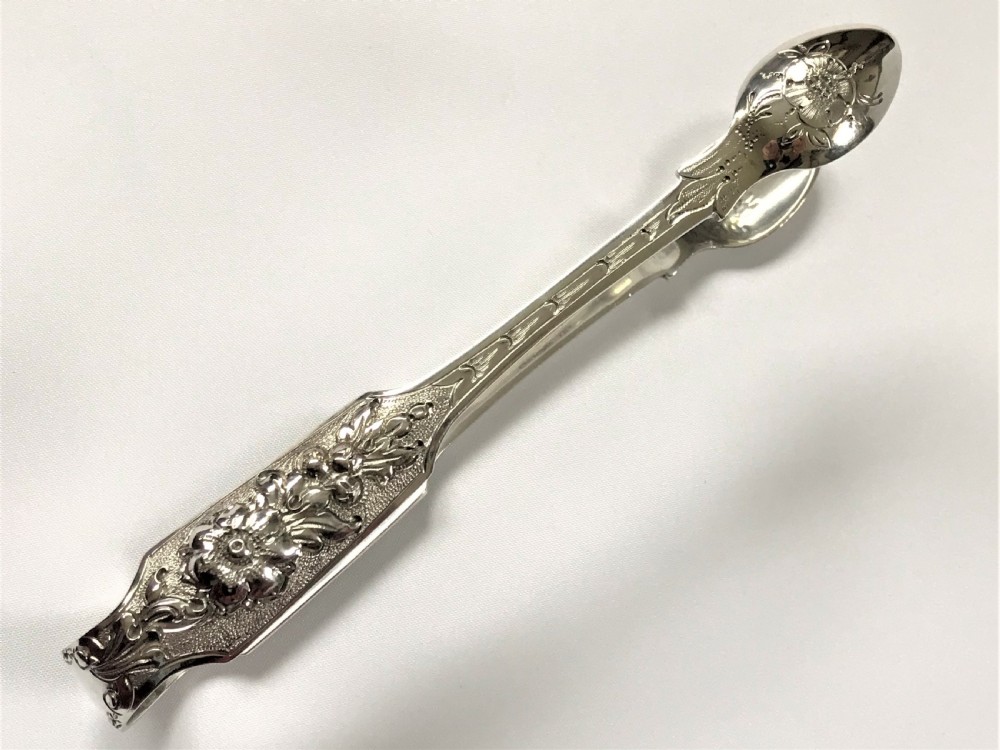 A fabulous pair of cast Irish silver tongs