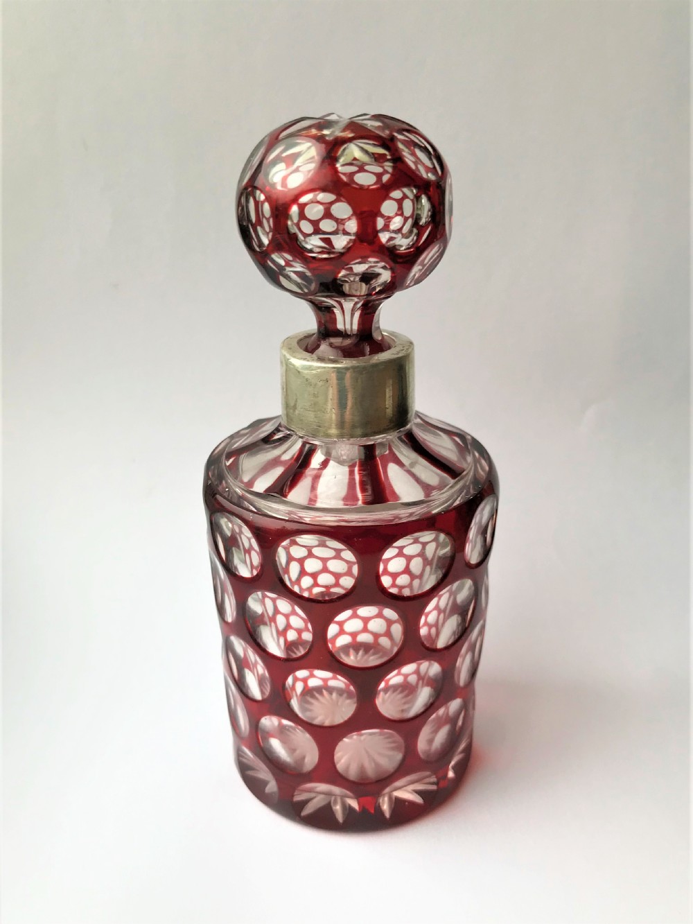 A gorgeous silver mounted ruby glass cologne bottle
