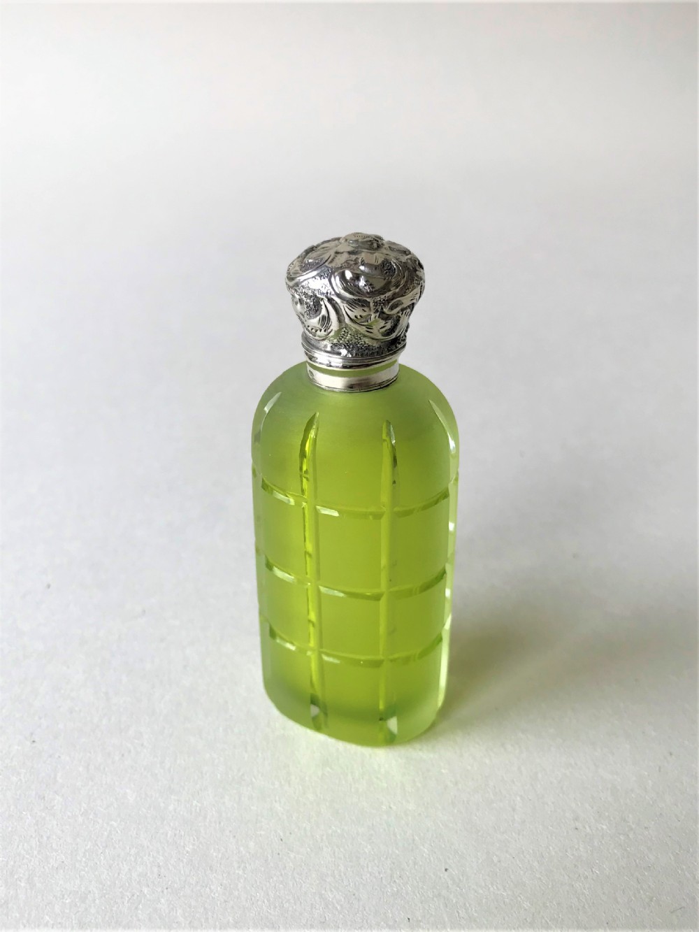A stunning acid green silver mounted scent bottle