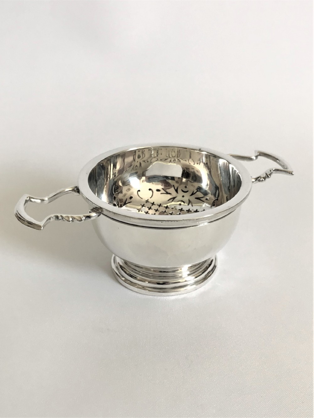 A superb silver tea strainer & drip cup