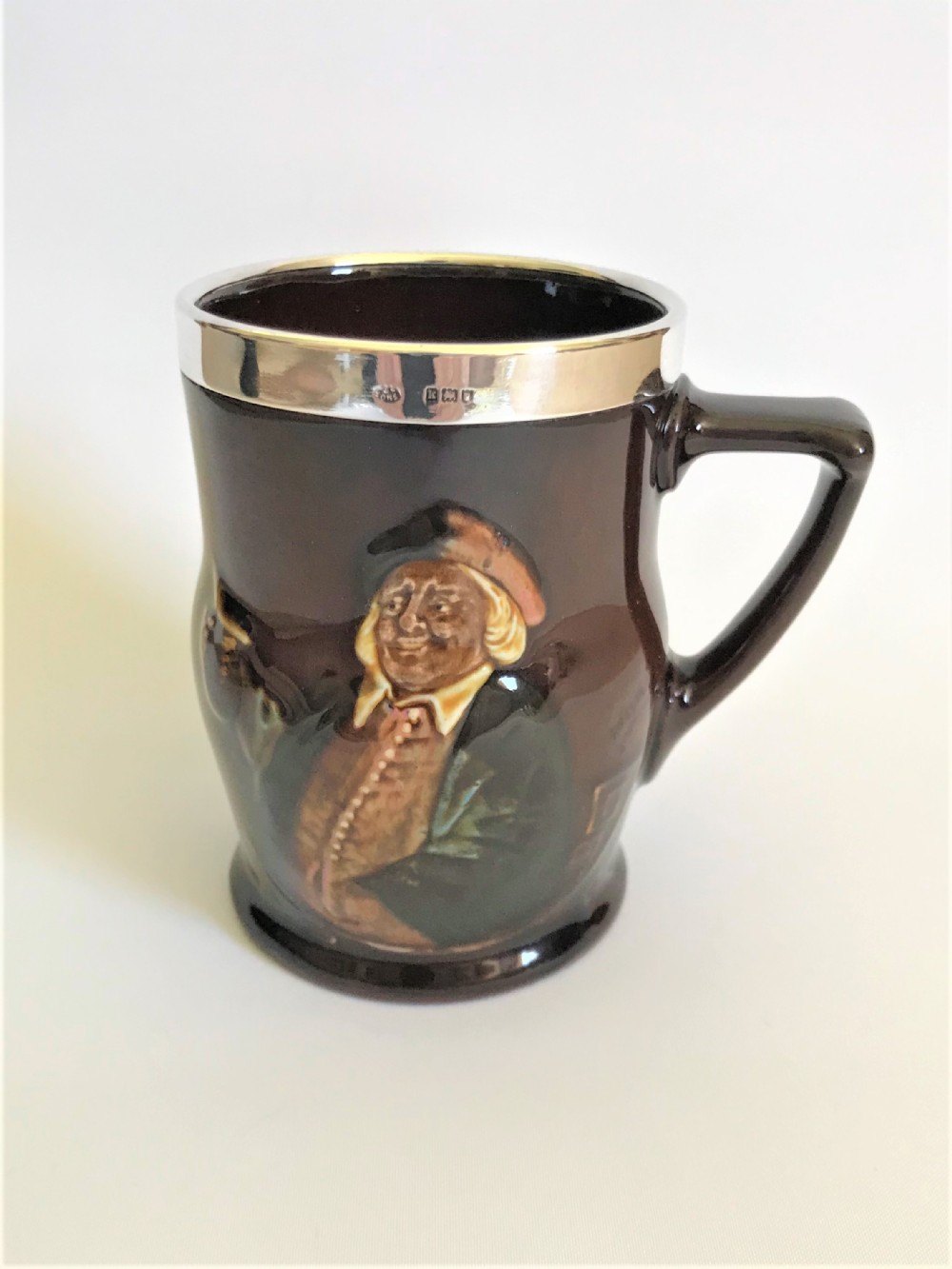 An Edwardian silver mounted Royal Doulton tankard