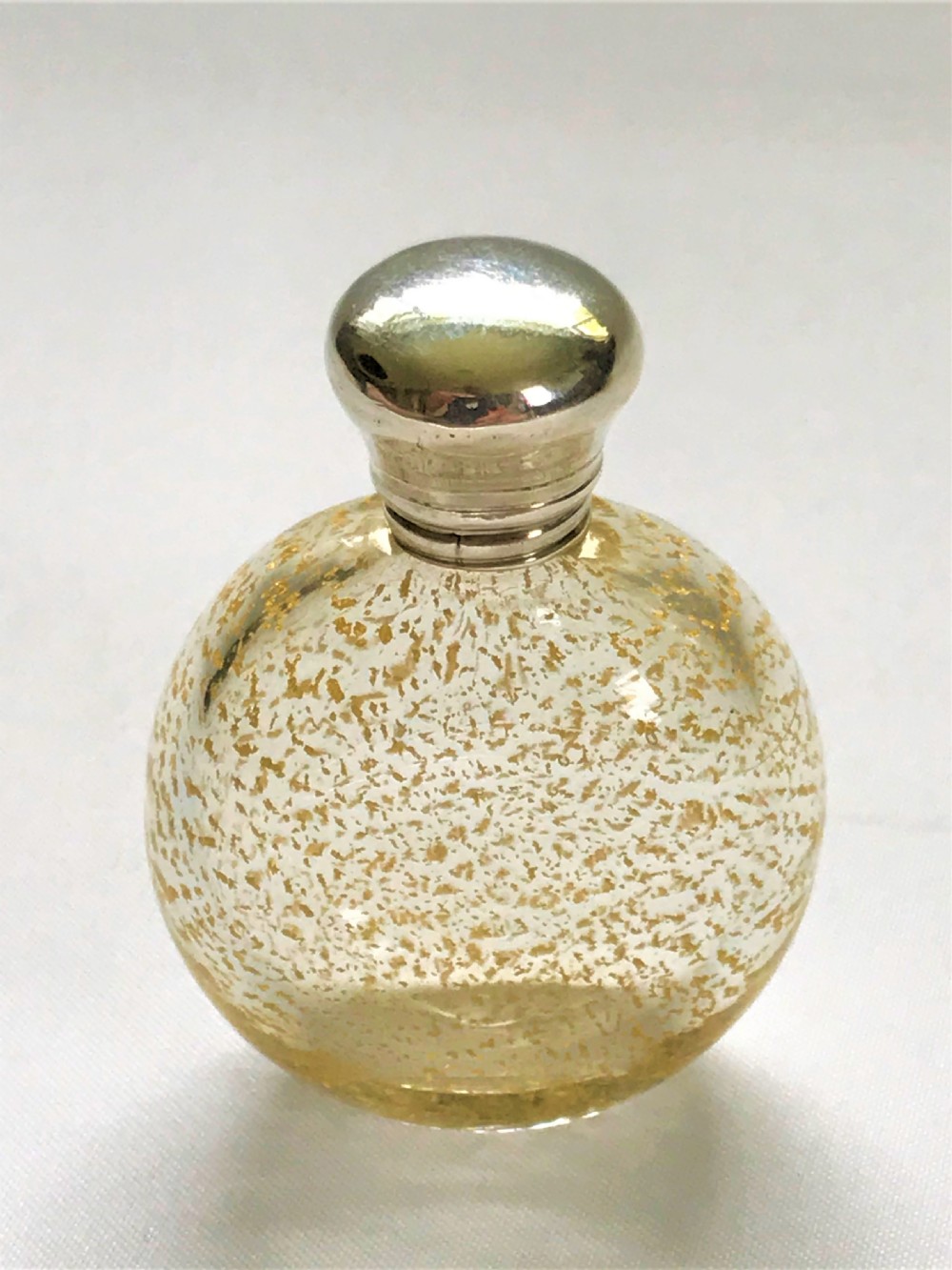 A gorgeous silver mounted gold leaf flecked scent bottle