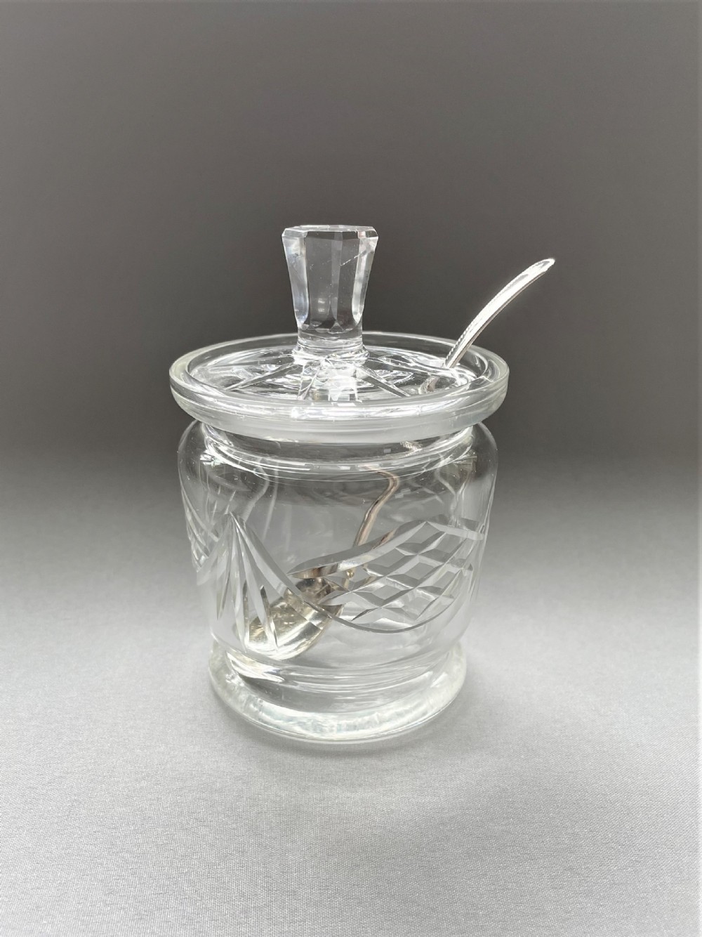 A cut glass Edwardian preserve jar with hallmarked silver spoon