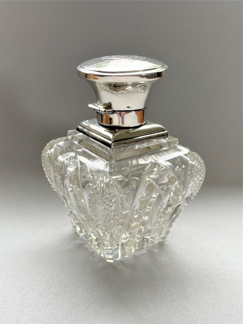 A stunning silver mounted cut glass table cologne bottle