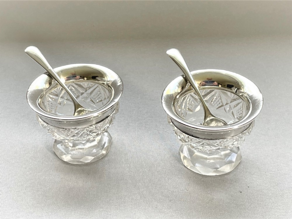 A charming silver mounted salt & pepper duo & spoons