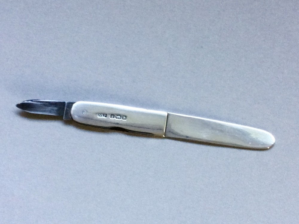 A charming silver pocket letter opener/paper cutter combo
