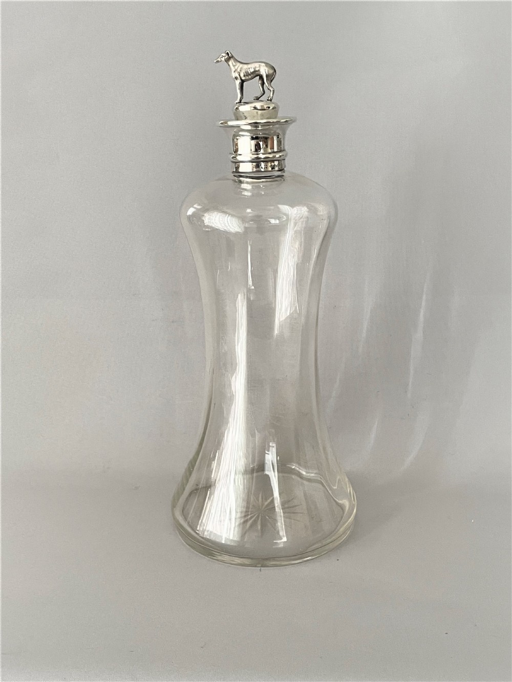 A rare Victorian silver mounted decanter with greyhound stopper