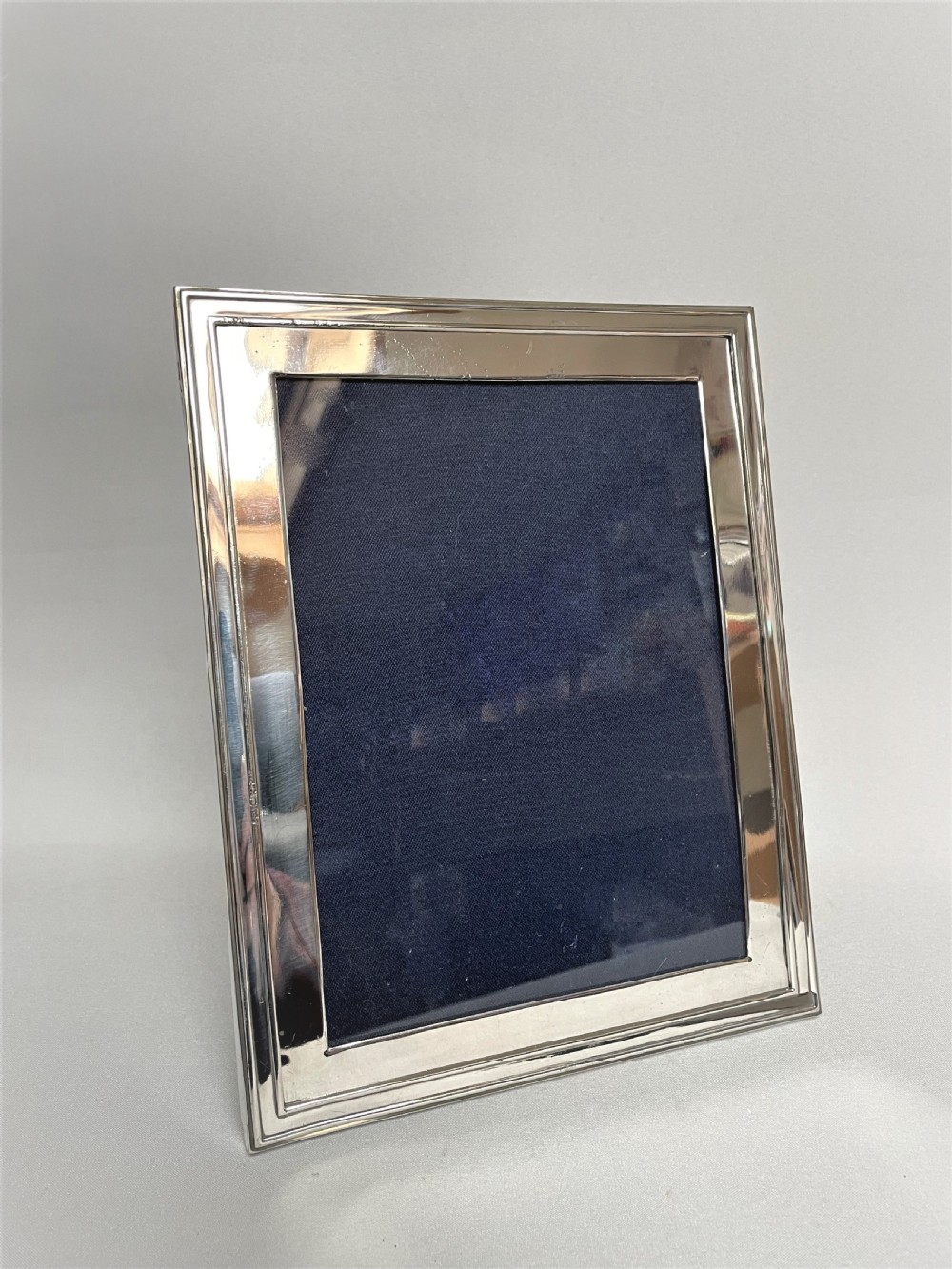 A large silver photo frame with unusual silver mount