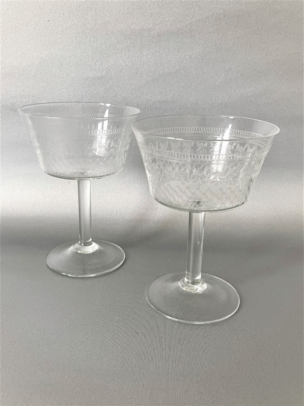 An elegant pair of Edwardian etched champagne coupes