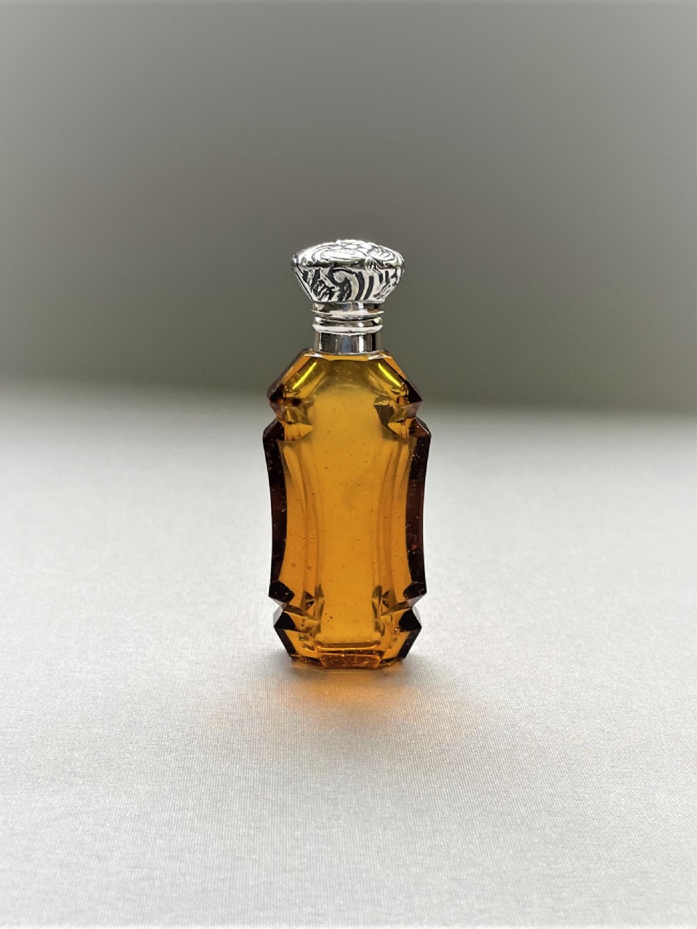 An unusual Victorian silver mounted amber glass scent bottle