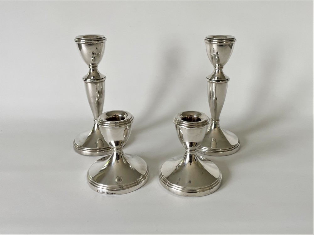 An unusual set of 4 hallmarked silver candlesticks
