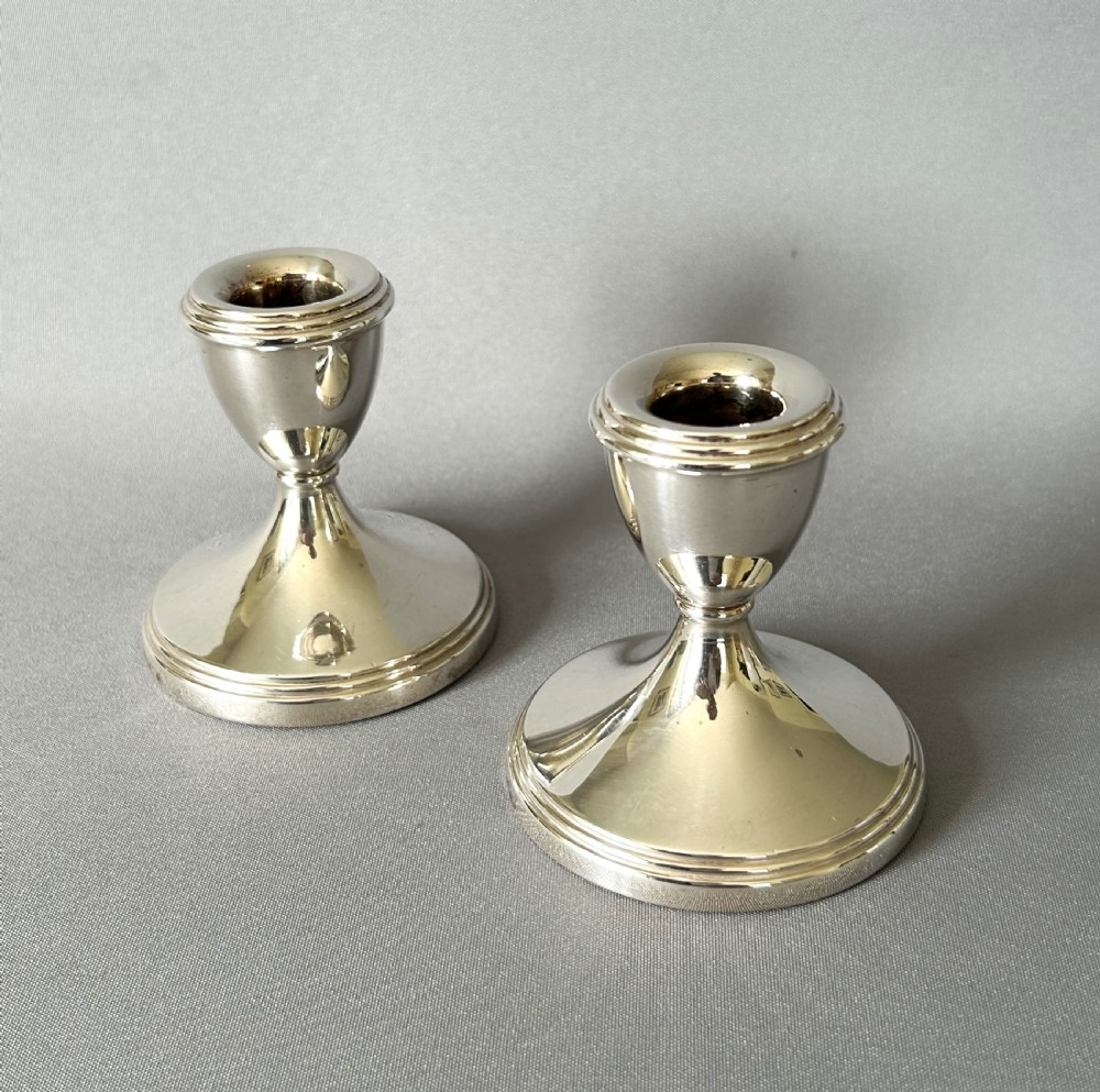 A charming pair of silver dwarf candlesticks