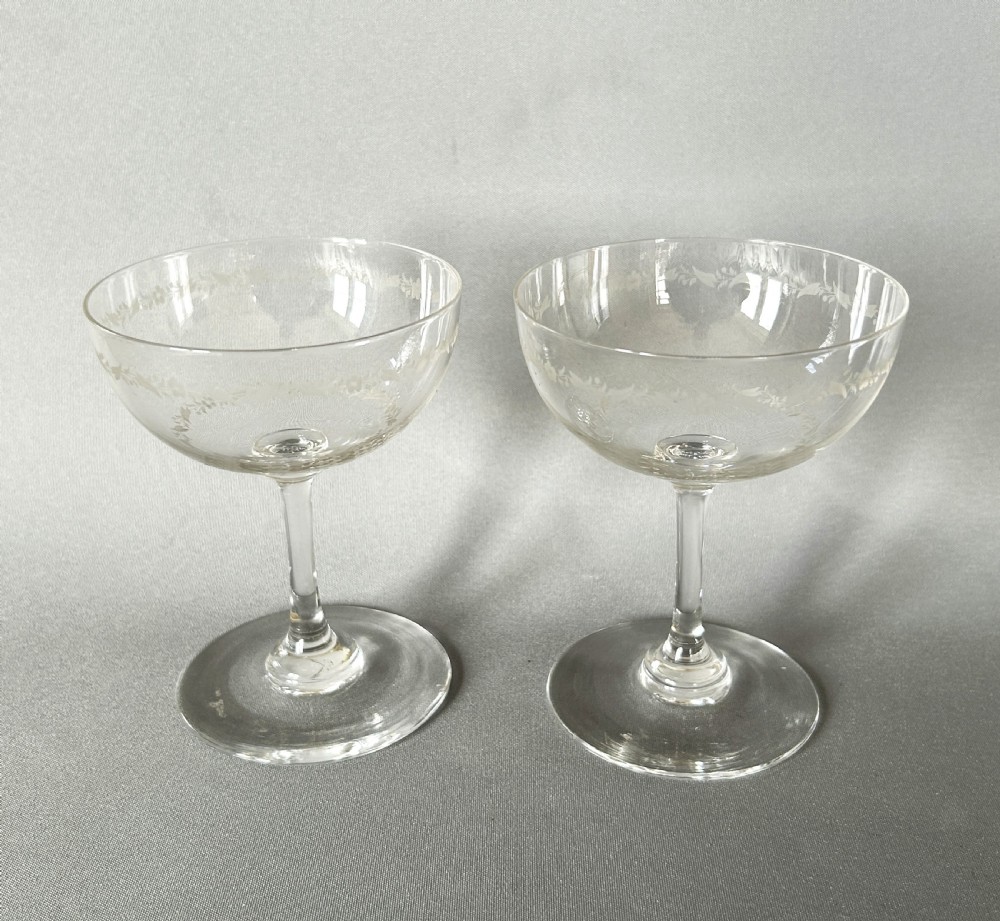 A charming pair of Edwardian etched glass champagne bowls
