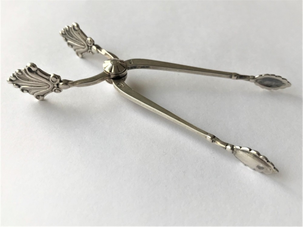 A pair of sterling silver Art Deco sugar nips featuring stylized fan motifs near the pivot and decorative grips.