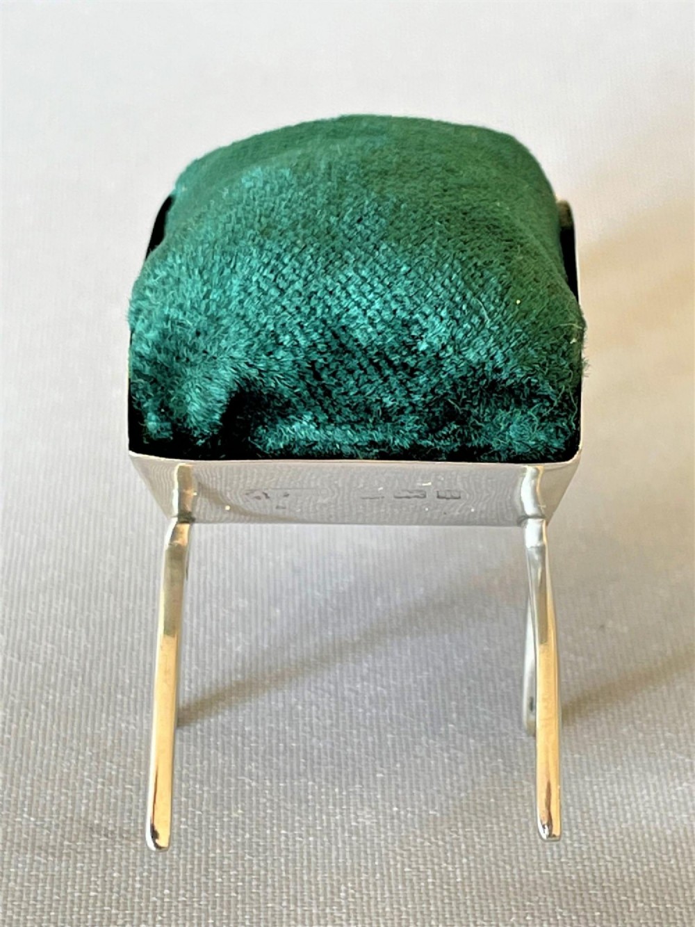 An Edwardian sterling silver pin cushion in the shape of a miniature wheelbarrow with a dark green velvet insert. View IV
