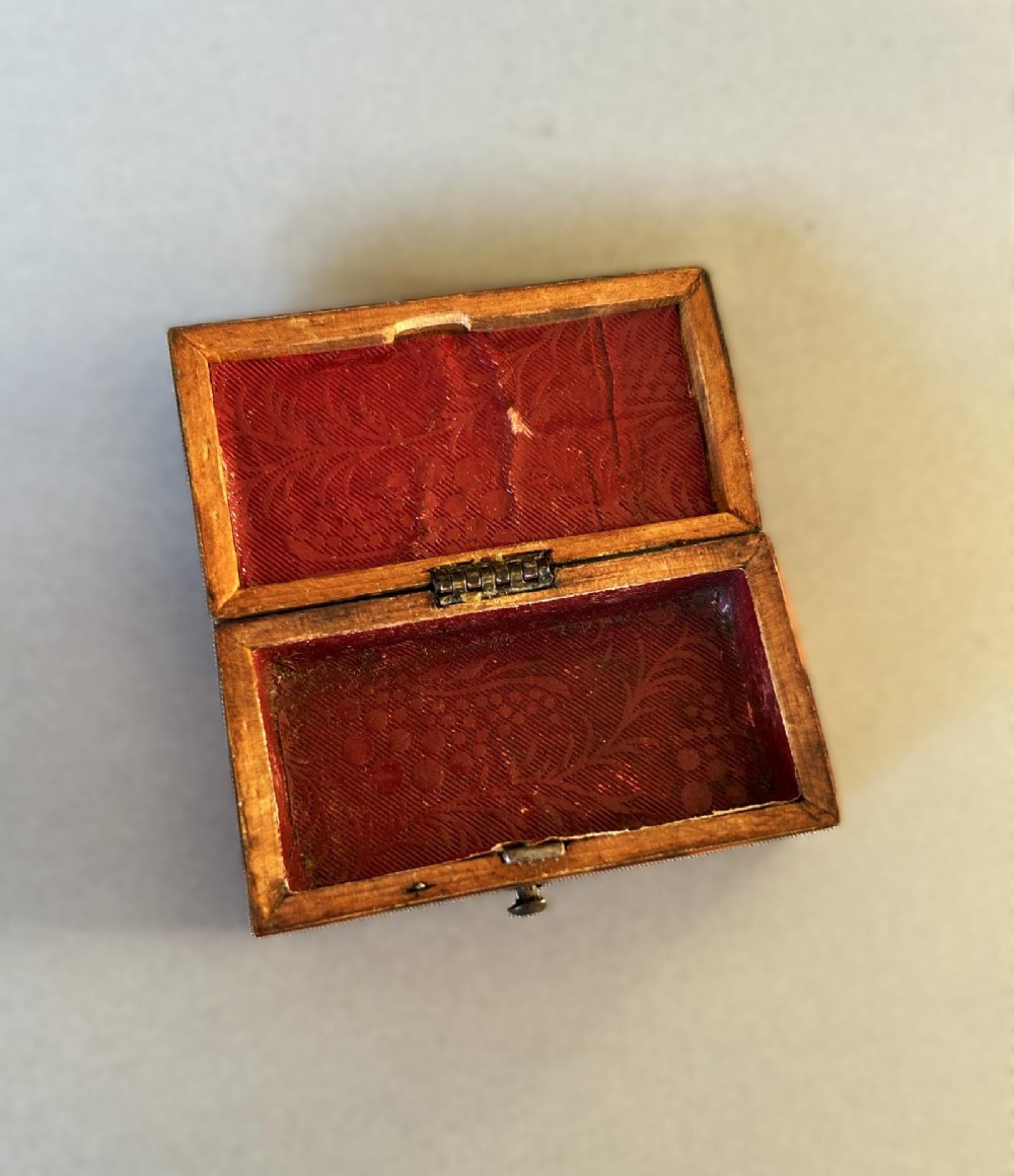 A mid-19th-century rectangular tortoiseshell snuff box featuring a curved top lid and a blank silver cartouche inlay. View V