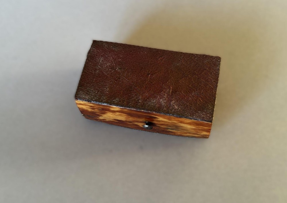A mid-19th-century rectangular tortoiseshell snuff box featuring a curved top lid and a blank silver cartouche inlay. View VI