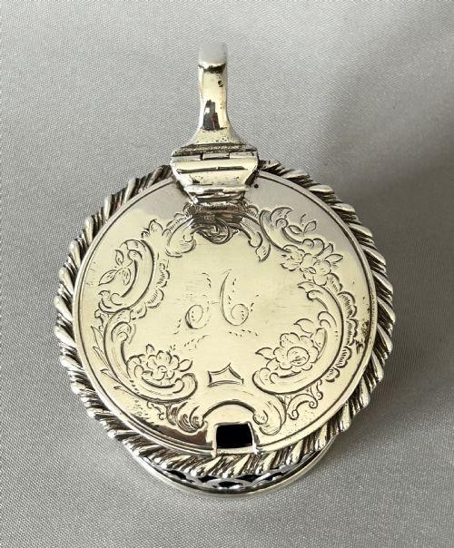 An early Victorian silver mustard pot with pierced fretwork sides, a cobalt blue glass liner, an engraved flat hinged lid, and a scroll handle. View X