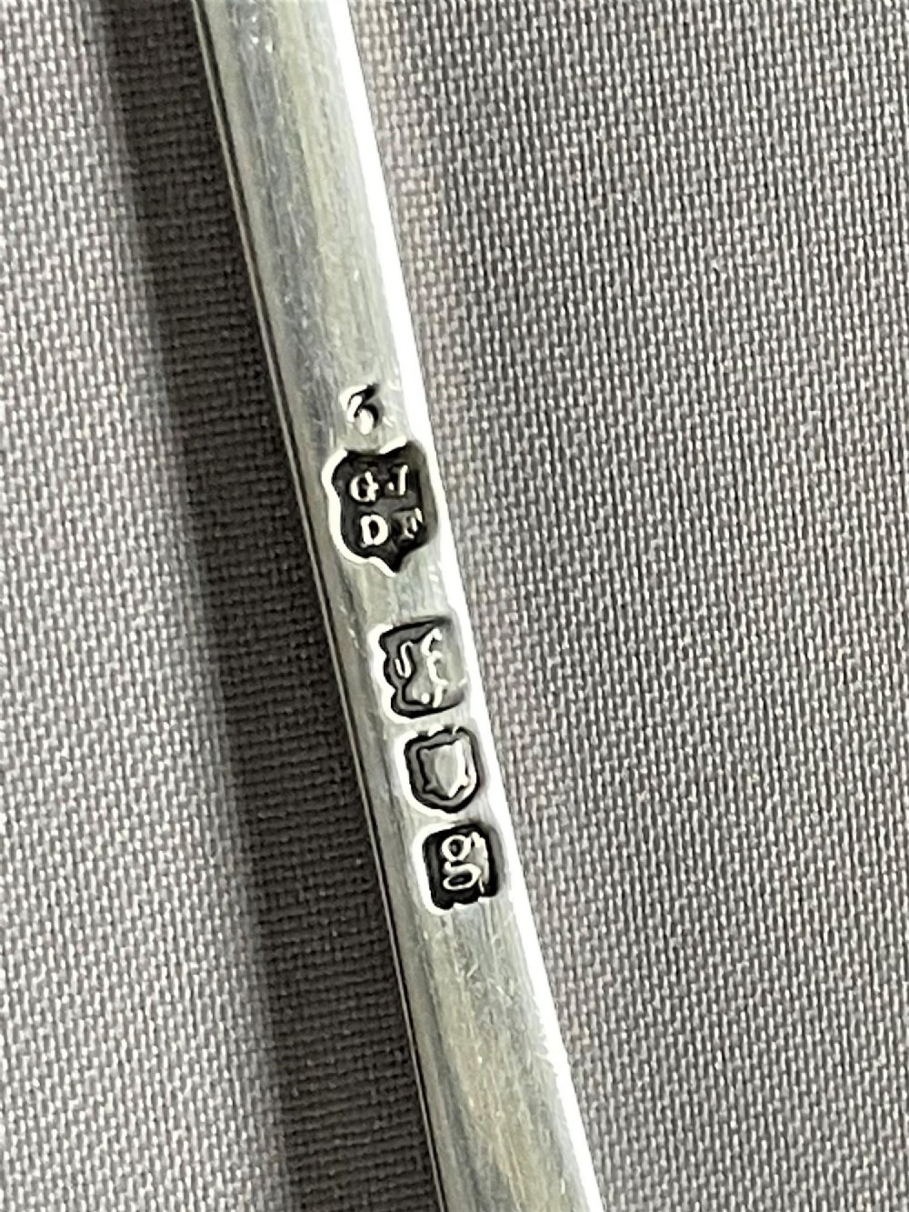 A pair of Edwardian silver salad servers consisting of a spoon and a fork with stylized leaf-shaped bowls and scroll-embossed handle terminals. View IV