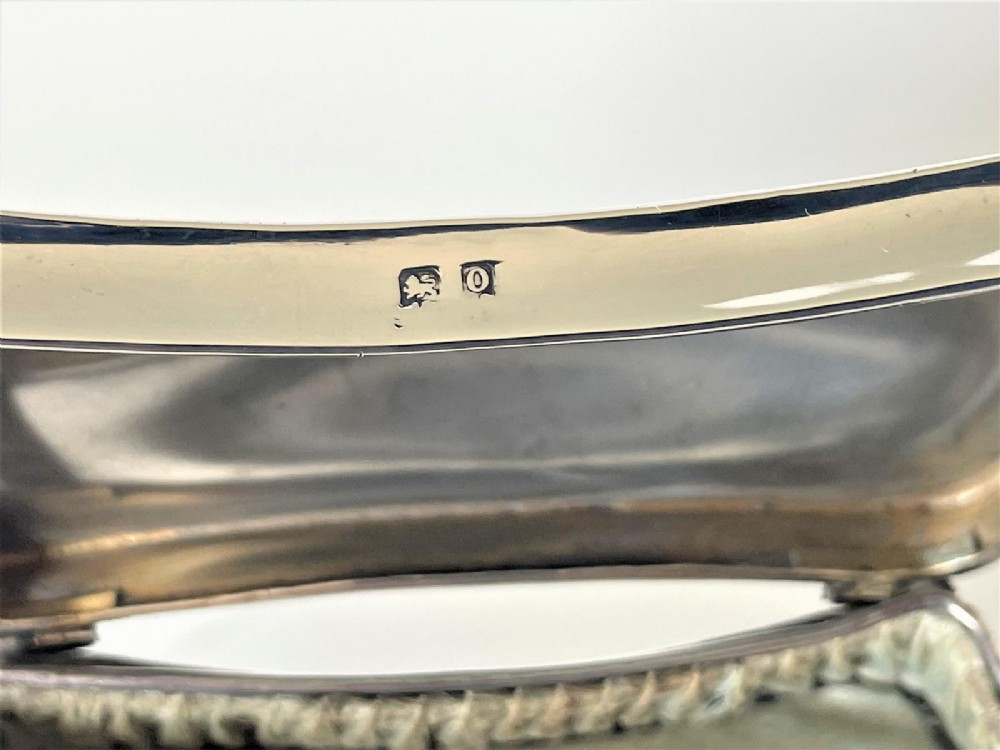 A polished George V sterling silver trinket box featuring a shaped flared body, hinged lid, and four cabriole legs. View VI