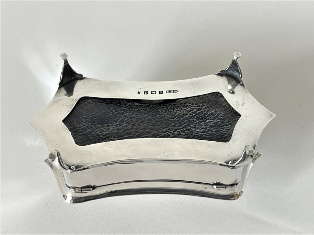 A polished George V sterling silver trinket box featuring a shaped flared body, hinged lid, and four cabriole legs. View IX