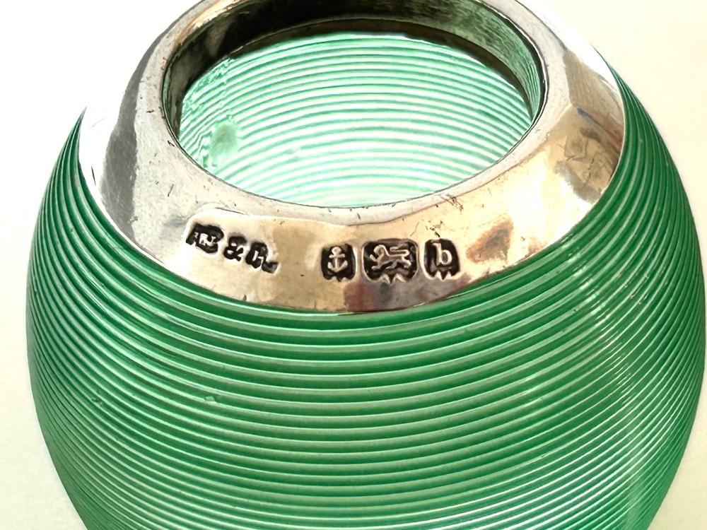 A spherical emerald green glass match striker featuring ribbed horizontal grooves and a hallmarked sterling silver collar at the rim. View VII