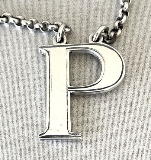 An early Victorian silver decanter label formed in the shape of the letter P and suspended on a silver chain. View III
