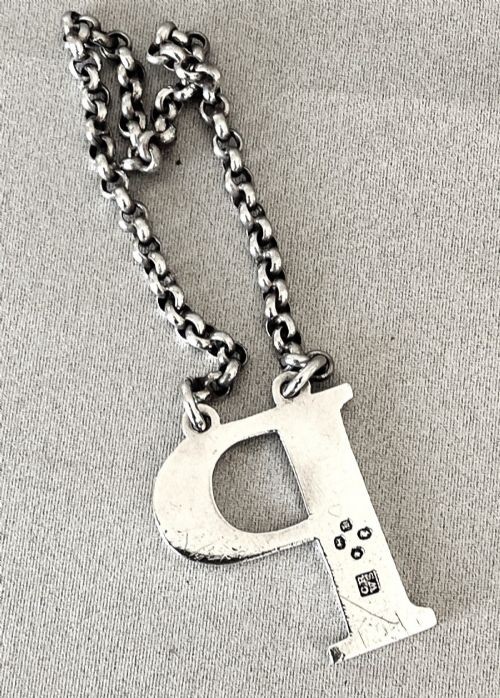 An early Victorian silver decanter label formed in the shape of the letter P and suspended on a silver chain. View IV