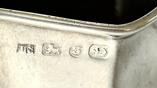 A late Victorian silver cream jug featuring embossed relief leaf motifs around its lower body and a beaded scroll handle. View V