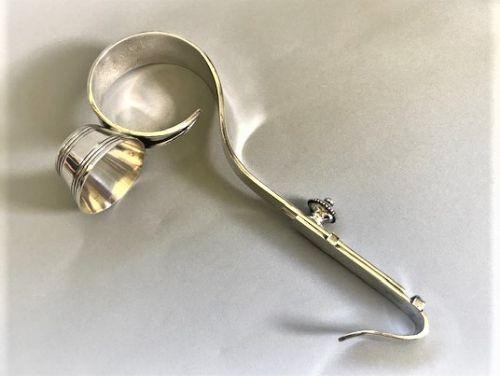 An Edwardian silver-plated champagne bottle holder featuring an adjustable collar mechanism and a curved pouring handle. View IV