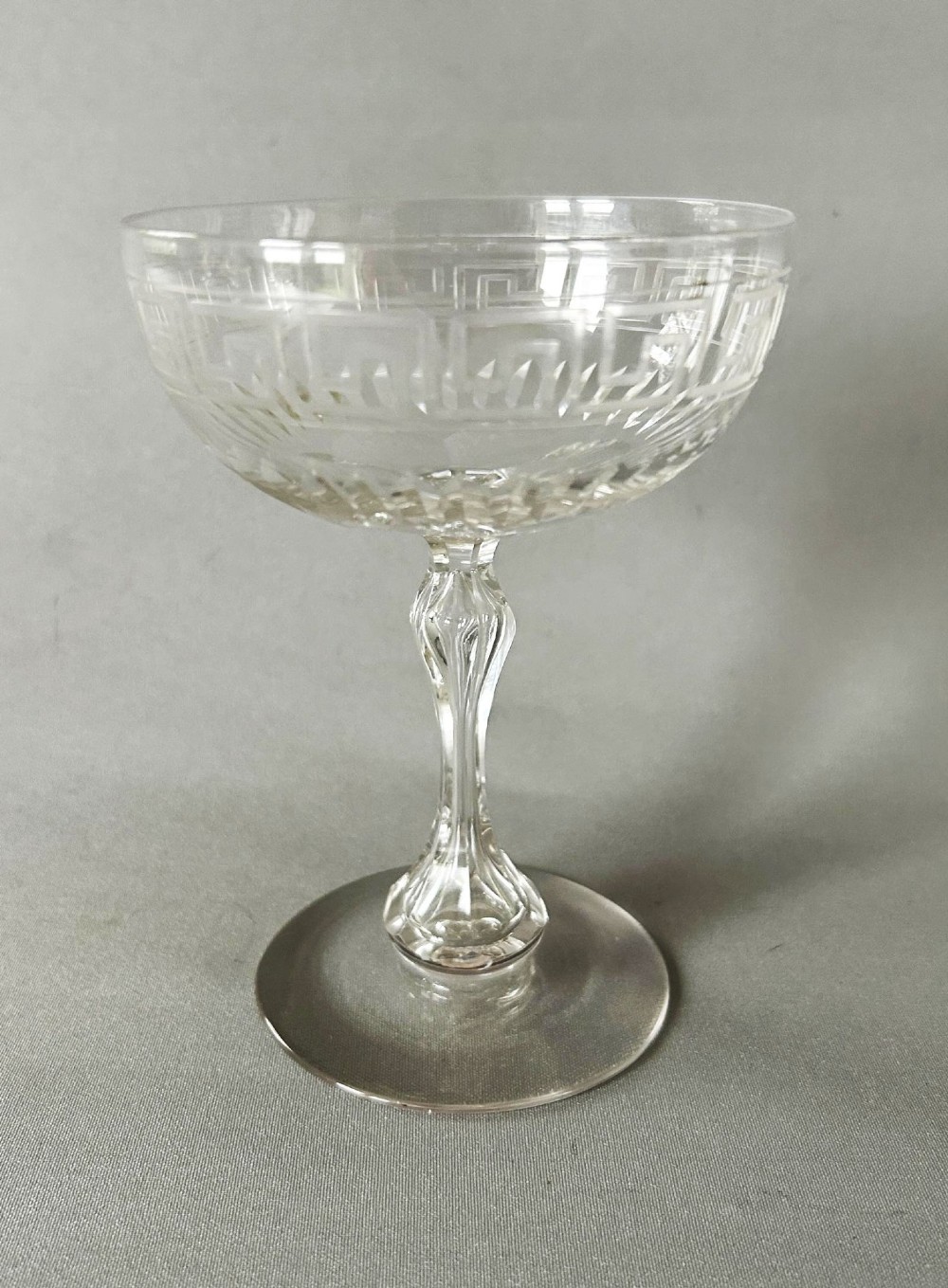 A harlequin set of six clear Victorian glass champagne coupes featuring varied etched motifs including starbursts and Greek key patterns. View III