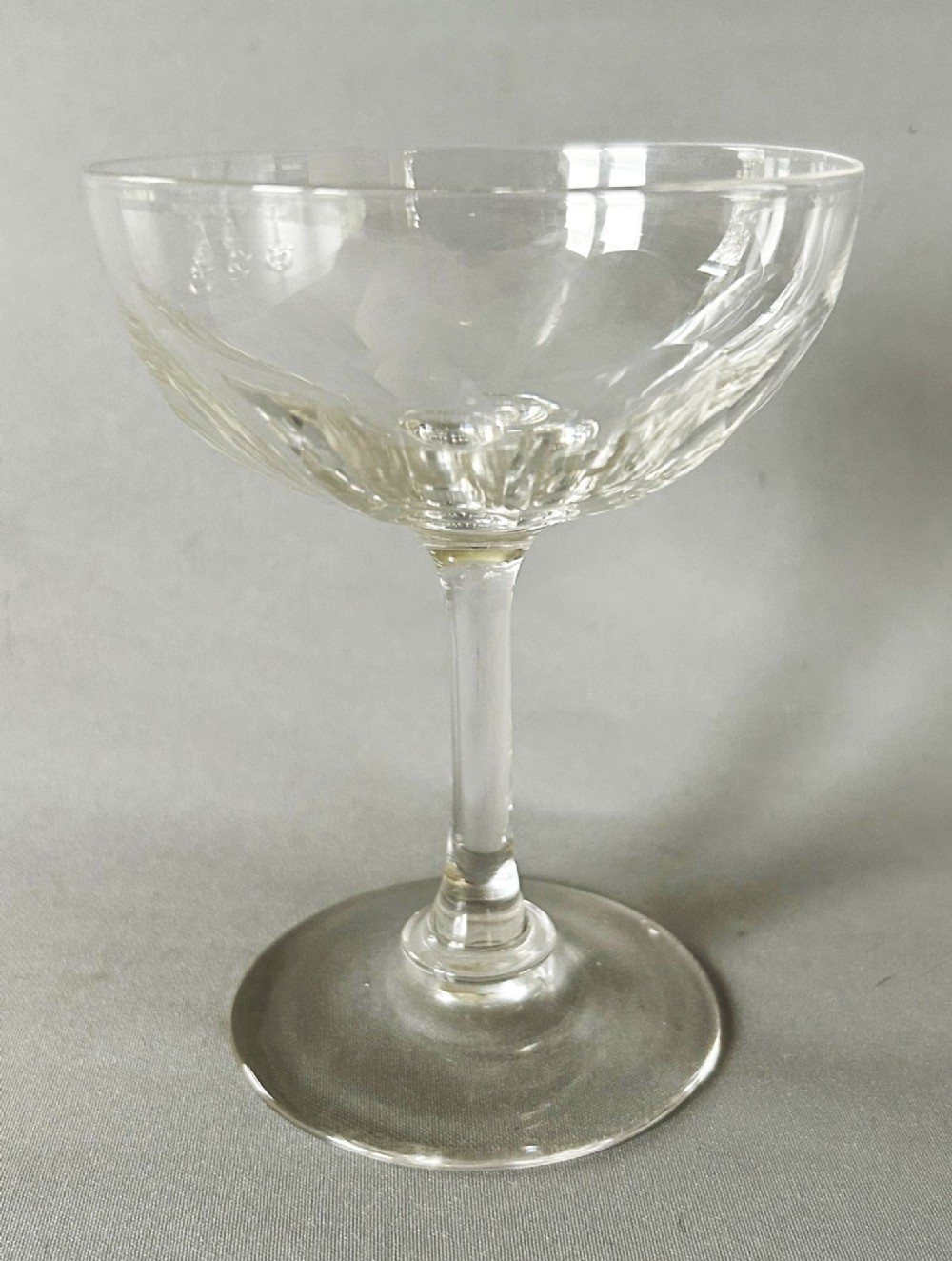A harlequin set of six clear Victorian glass champagne coupes featuring varied etched motifs including starbursts and Greek key patterns. View V