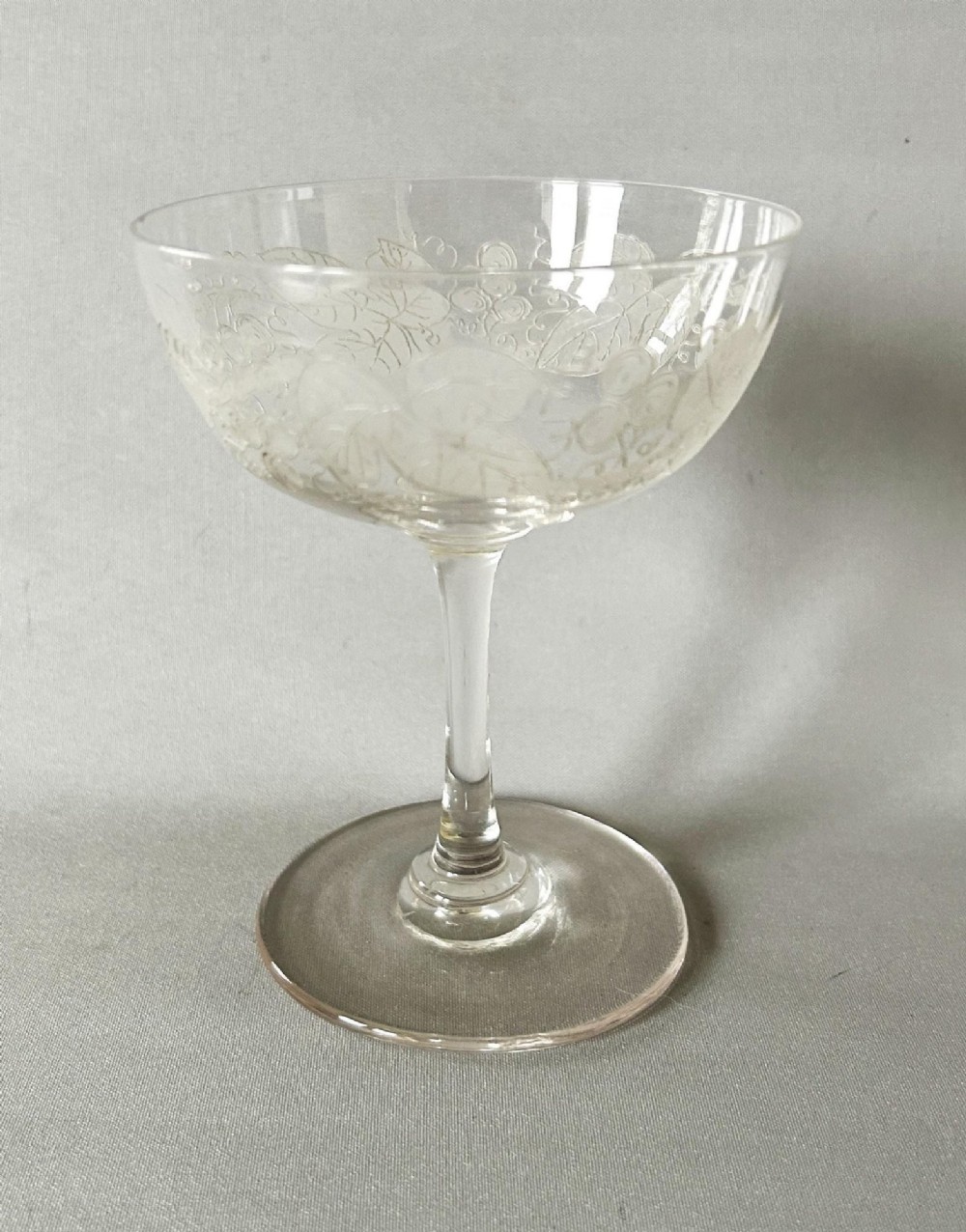A harlequin set of six clear Victorian glass champagne coupes featuring varied etched motifs including starbursts and Greek key patterns. View VII