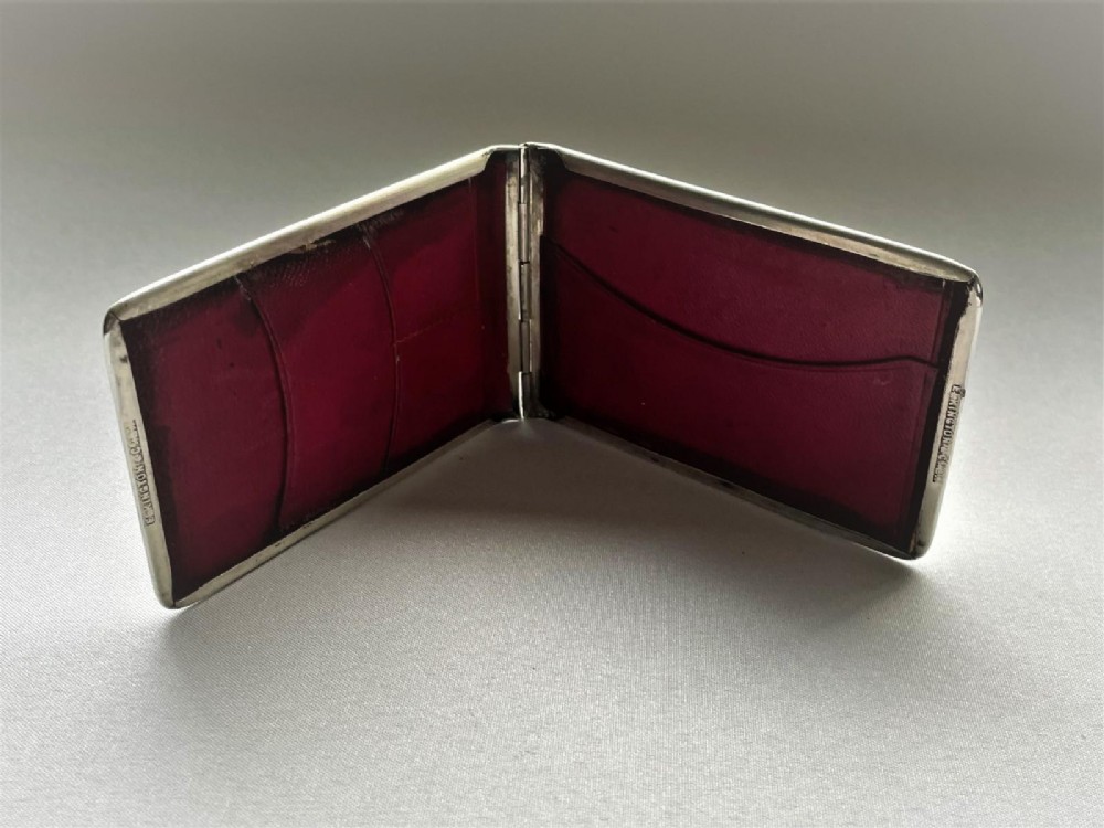A rectangular Edwardian sterling silver wallet and stamp case displaying visible British silver hallmarks on its smooth metallic exterior. View II