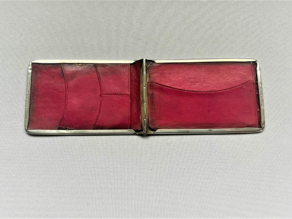A rectangular Edwardian sterling silver wallet and stamp case displaying visible British silver hallmarks on its smooth metallic exterior. View VI