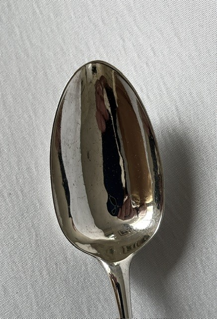 A Georgian sterling silver tablespoon featuring an elongated oval bowl and a smooth tapered stem against a light grey background. View V