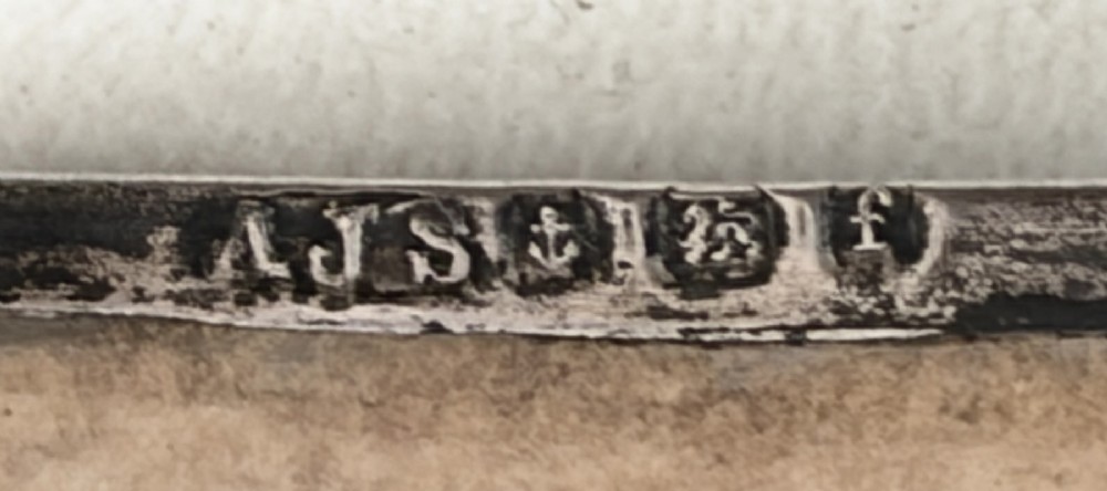 A miniature Edwardian book-shaped pocket calendar featuring an embossed silver front cover with detailed scrollwork and a central latticework pattern. View VI