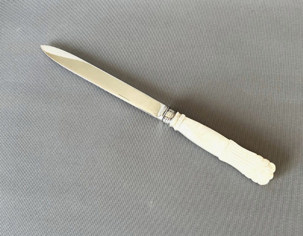 An antique Georgian letter opener featuring a tapered silver blade with stamped hallmarks and a carved cream mother of pearl handle. View III