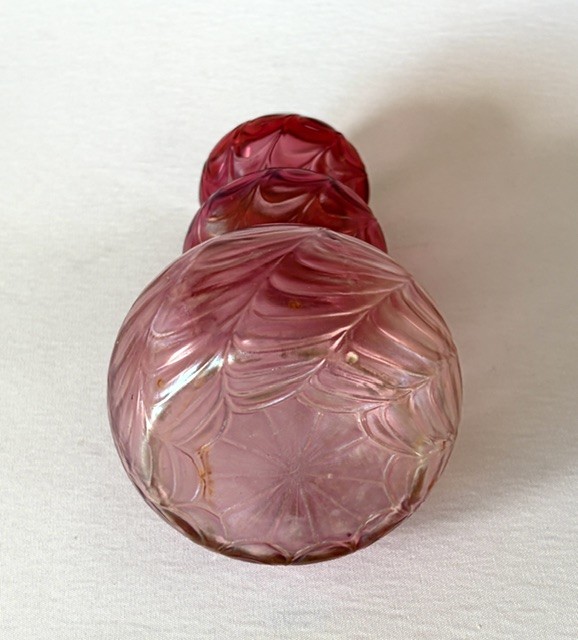 An Art Nouveau iridescent glass vase featuring a lobed, swirling magenta to pink body fitted with a polished sterling silver rim collar. View V