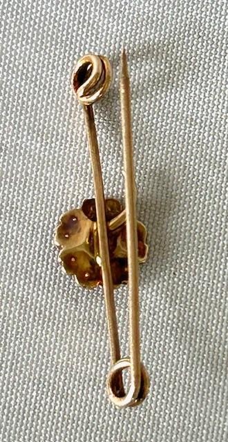 A 9ct gold bar brooch featuring a central floral cluster motif set with a round turquoise cabochon encircled by seed pearls. View V