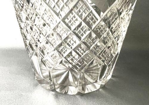 A clear cut-glass water jug featuring a loop handle, horizontal step cuts around the neck, and diamond facets across the lower body. View IV