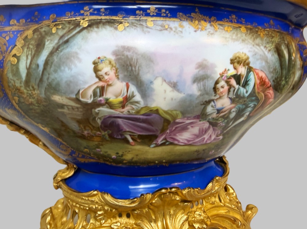 A mid-19th-century cobalt blue porcelain centrepiece bowl featuring a hand-painted pastoral scene, gilded foliage patterns, and cast gilt bronze scroll handles and base. View III