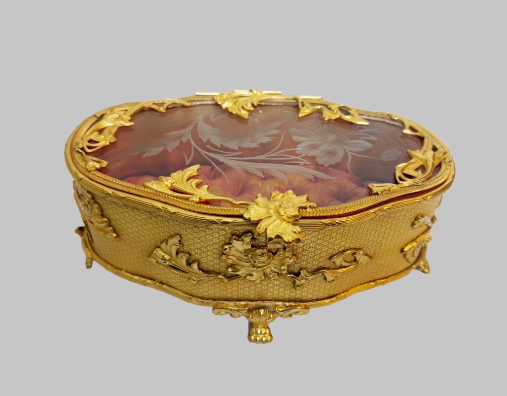 An oval nineteenth-century gilt bronze jewellery box featuring textured foliate relief work, scroll feet, and an etched glass lid. View II